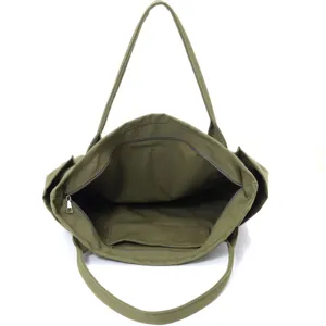 Green canvas tote bag interior detail view, casual shoulder bag with zipper and inner pocket.