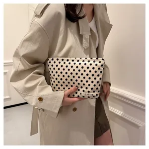 Detailed close-up view of a stylish black and white polka dot canvas cosmetic pouch.