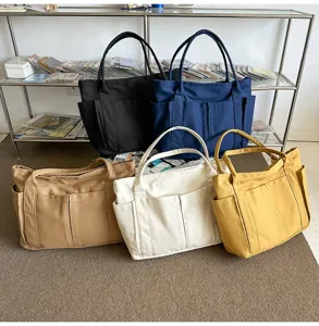 Canvas tote bag detail showing multi-color options and functional exterior utility pockets.