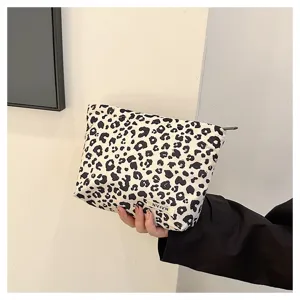 Black and white leopard print cosmetic bag, portable makeup organizer with zipper closure.