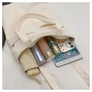 Detail view of a large-capacity canvas tote bag filled with daily items like cosmetics and tablet.