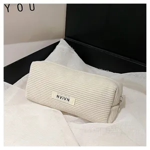 Gedetailleerd overzicht van het retro beige corduroy etui met zachte textuur en stevige rits.