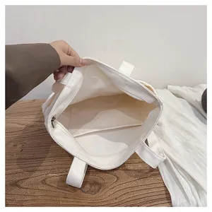 Canvas tote bag interior detail view showing spacious compartment and secure zipper pocket.