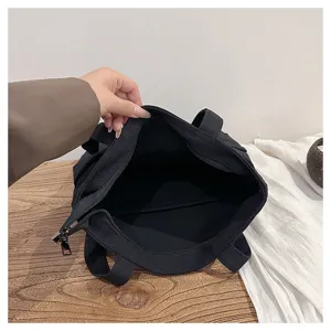 Detailed view of the black canvas tote bag interior, showing zipper closure and large capacity.