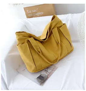 Yellow canvas tote bag detail, large capacity shoulder bag with multiple side pockets.
