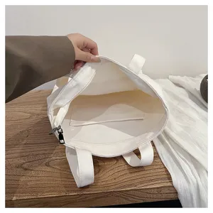 Detailed view of the white canvas tote bag interior showing zipper and inner pocket design.