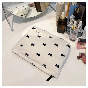 Corduroy cosmetic bag with cute bow pattern, portable makeup storage pouch and clutch handbag for daily use.