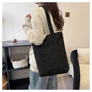 Black canvas tote bag with multiple pockets, casual shoulder bag for women daily use.