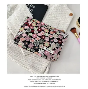 Portable floral cosmetic bag with zip closure, stylish woven pouch for daily makeup storage.