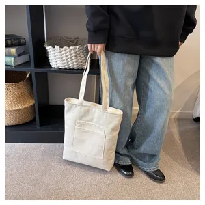 Solid color canvas shoulder bag with front pocket, casual large capacity student tote bag.