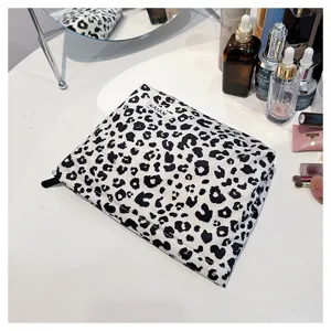 Leopard print cosmetic pouch detail view, black and white pattern canvas makeup bag with zipper closure.