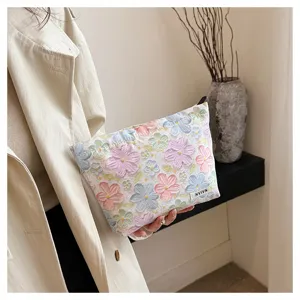 Detailed shot of 3D floral cosmetic bag with embossed flower pattern and convenient storage pouch.