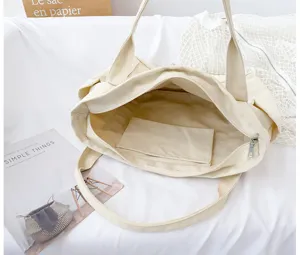Canvas tote bag interior detail, large capacity beige shoulder bag with zipper and inner pocket.