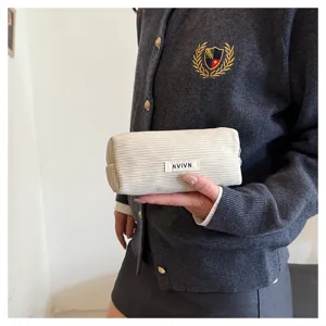 Gedetailleerd overzicht van het retro beige corduroy etui met fijne textuur en label.