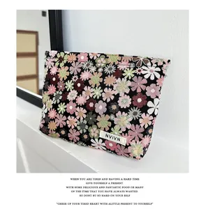 Close-up detail of the floral cosmetic pouch featuring colorful pattern and secure zipper.
