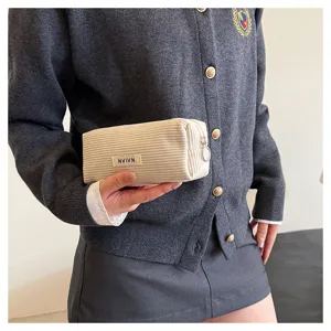Gedetailleerd overzicht van het retro ribfluwelen etui met zachte textuur en handige rits.