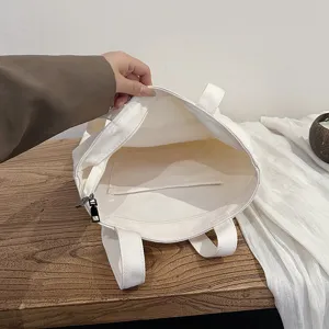 Simple solid color canvas tote bag with zipper closure and interior pockets for daily use.