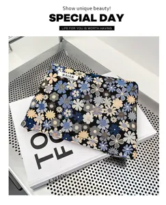 Detailed view of a portable floral cosmetic bag with jacquard daisy pattern on metal shelf.
