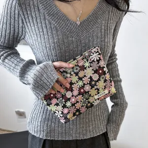 Portable floral cosmetic bag for women, stylish clutch purse for travel makeup storage and daily use.