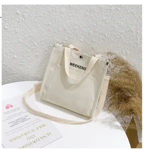 Canvas tote bag with weekend print, shoulder strap and front pocket detail for daily use.