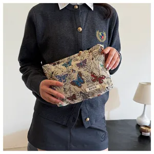 Detailed view of vintage tapestry makeup bag with butterfly pattern, elegant storage pouch.