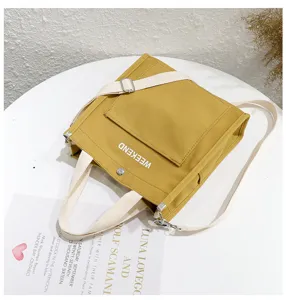 Casual yellow canvas tote bag with shoulder strap and front pocket, perfect for daily student use.