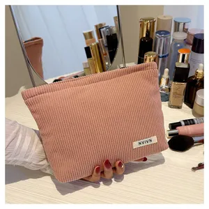 Corduroy cosmetic bag detail shot showing soft pink fabric texture and neat stitching.