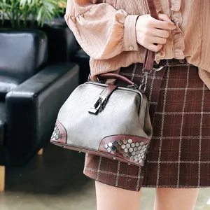 Stylish women shoulder handbag with metal lock, vintage doctor bag design and rivet decor.