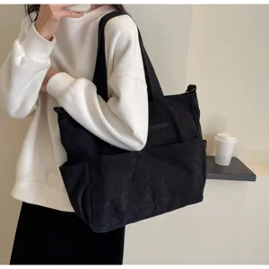 Black corduroy tote bag detail showing large capacity, soft texture and comfortable shoulder strap.
