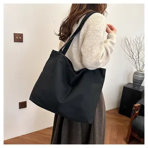Minimalist black canvas tote bag, large capacity daily shoulder bag lifestyle detail.