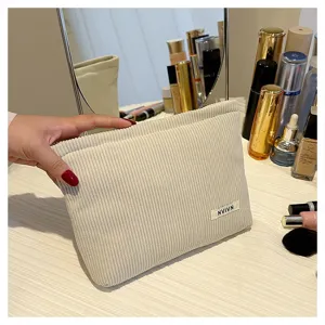 Solid color corduroy cosmetic bag for women, portable makeup pouch and stylish clutch bag.