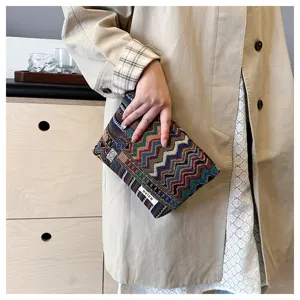 Close-up detail shot of ethnic woven cosmetic pouch and clutch bag with retro pattern.