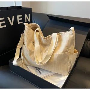 Beige corduroy shoulder bag, large capacity casual tote bag, simple commuter handbag design.