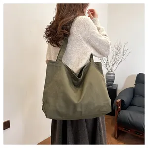 Detailed shot of large capacity dark green canvas tote bag styled for daily casual wear.