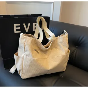 Detailed view of the casual beige corduroy tote shoulder bag featuring practical side pockets.