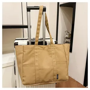 Canvas tote bag detail showing large capacity, dual top handles, and front pocket design.