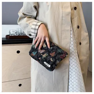 Detailed shot of fabric cosmetic pouch with delicate butterfly print and woven texture design.