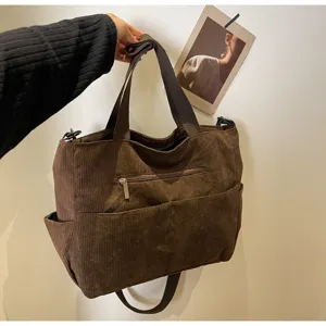 Brown corduroy tote bag detail showing texture, zipper pocket, and durable shoulder strap.