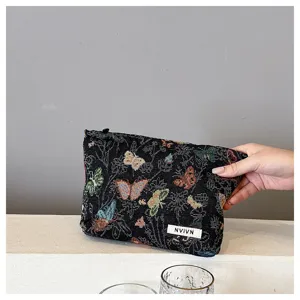 Detail view of the retro woven cosmetic bag featuring colorful butterfly patterns and neat zip.