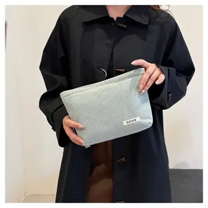 Light blue corduroy makeup bag with cute white brand label, handy pouch for daily use.