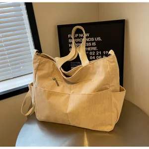 Beige corduroy tote bag detail view, featuring front zip pocket and spacious design.