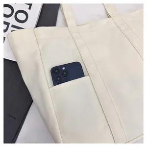 Canvas tote bag detail view showing front pocket design, sturdy straps, and daily storage.