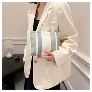 Detail view of the striped fabric cosmetic pouch, showing textured woven material and neat stitch.