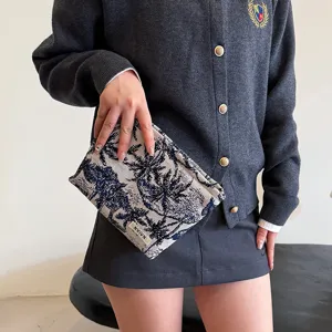 Vue détaillée de la trousse de maquillage en toile avec un motif de palmier élégant.