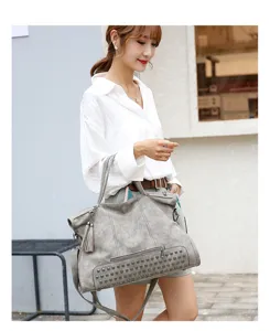 Detailed view of the grey women shoulder tote bag featuring stylish studs and tassels design.