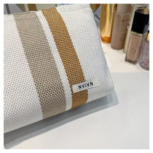 Detail view of the stylish woven striped cosmetic bag with neat texture and label.