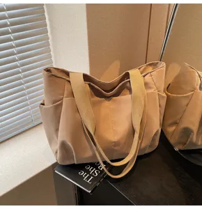 Minimalist beige canvas tote bag with shoulder straps, large capacity casual daily handbag.