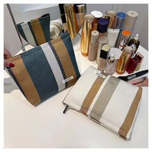 Detailed shot of striped cosmetic storage bag, portable canvas makeup pouch with zipper closure.
