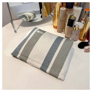 Detailed view of the striped linen cosmetic storage bag, portable fabric pouch design.