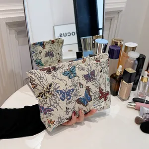 Detail view of the butterfly jacquard cosmetic pouch, showing delicate fabric texture and zipper.